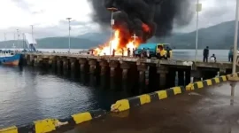 Asap hitam tebal membubung dari kapal BBM 02 Trans Floreti yang terbakar di Pelabuhan Larantuka.