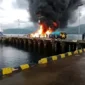 Asap hitam tebal membubung dari kapal BBM 02 Trans Floreti yang terbakar di Pelabuhan Larantuka.